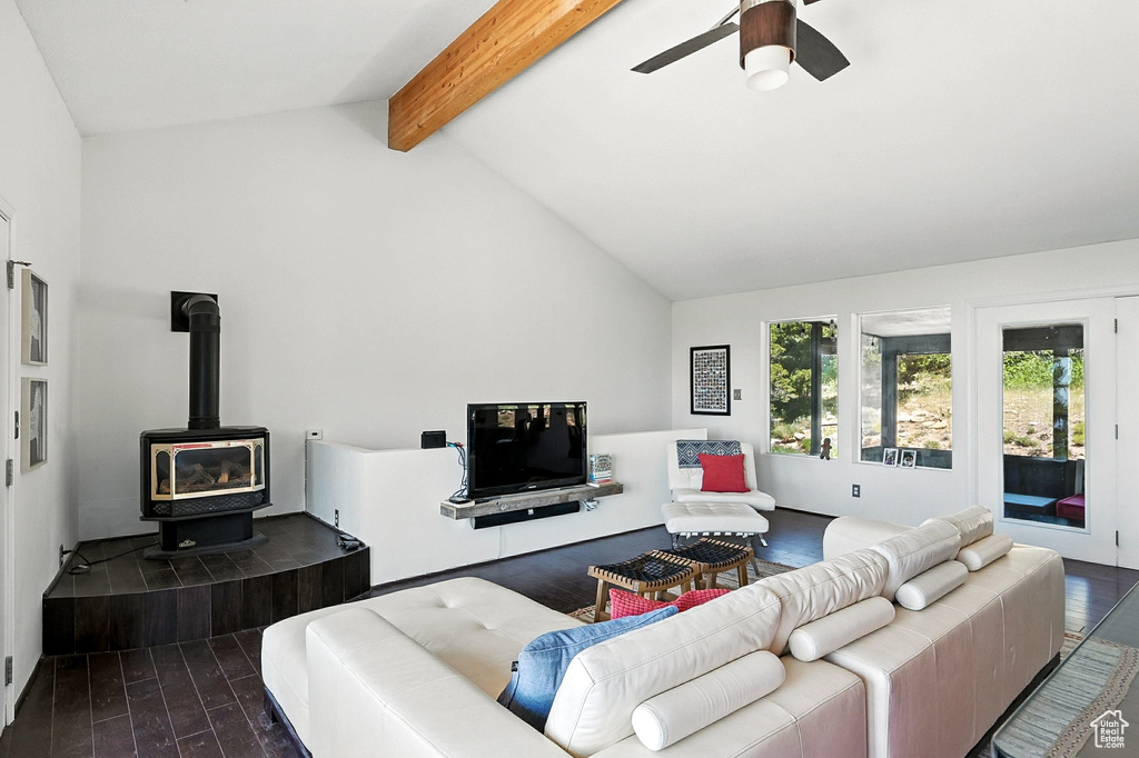 Living area featuring dark wood-style flooring, a wood stove, and ceiling fan
