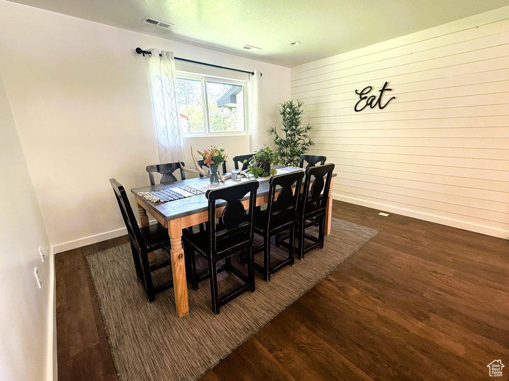 Dining space with wood finished floors and wood walls