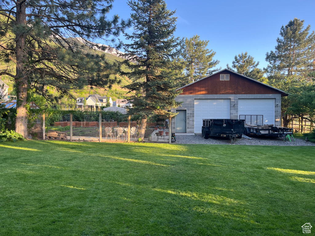View of green lawn with a garage and an outdoor structure