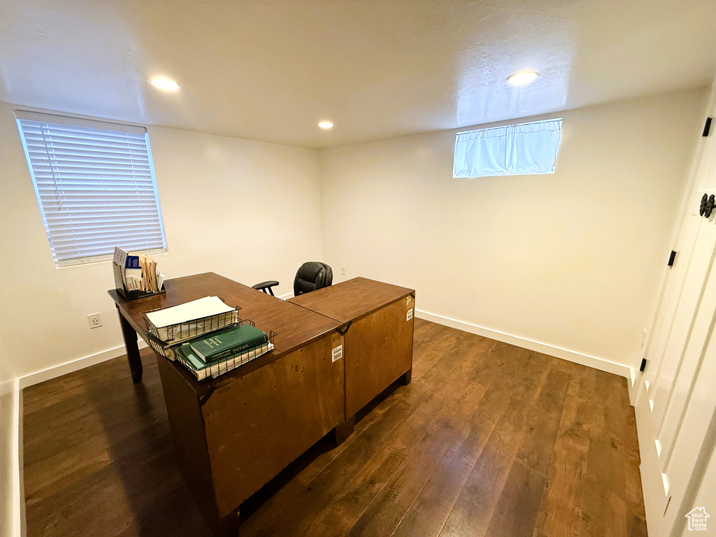 Office with dark wood-type flooring and recessed lighting