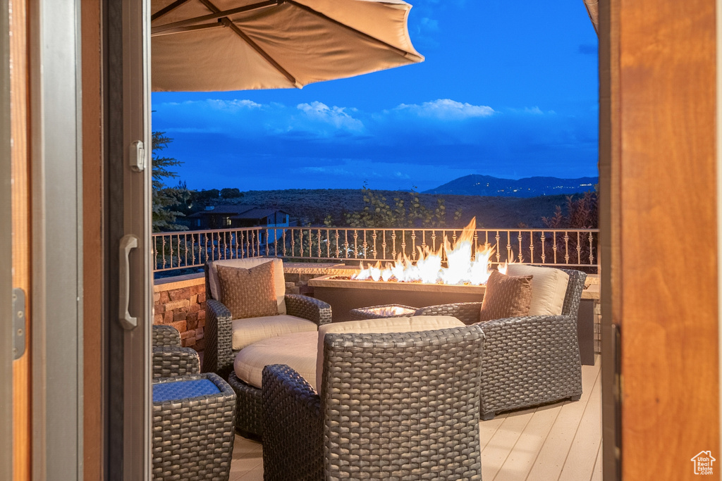 Balcony featuring an outdoor fire pit, a mountain view, and a sunroom