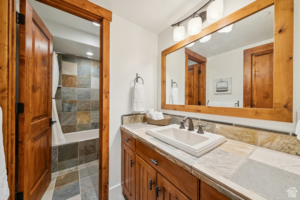 Full bathroom with vanity, tiled shower / bath combo, and recessed lighting