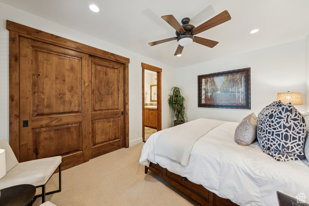 Bedroom with light carpet, recessed lighting, ensuite bath, and a ceiling fan