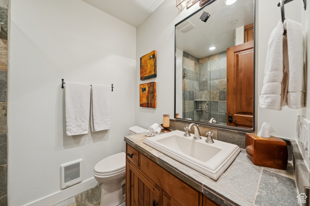 Full bath featuring vanity, a stall shower, and heating unit