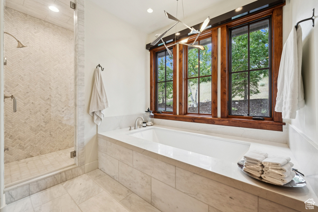 Bathroom featuring plenty of natural light, a stall shower, a garden tub, and recessed lighting