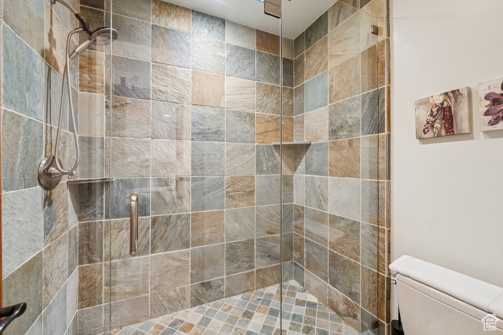 Bathroom featuring toilet and a shower stall
