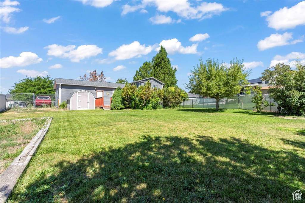 Fenced backyard featuring a shed