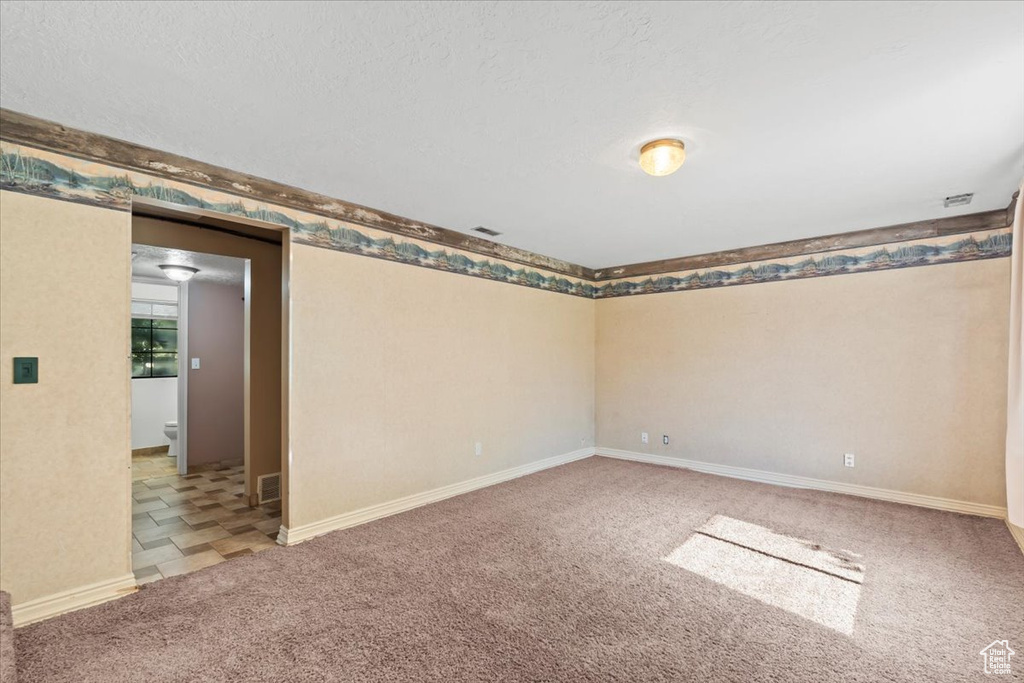 Carpeted spare room with baseboards