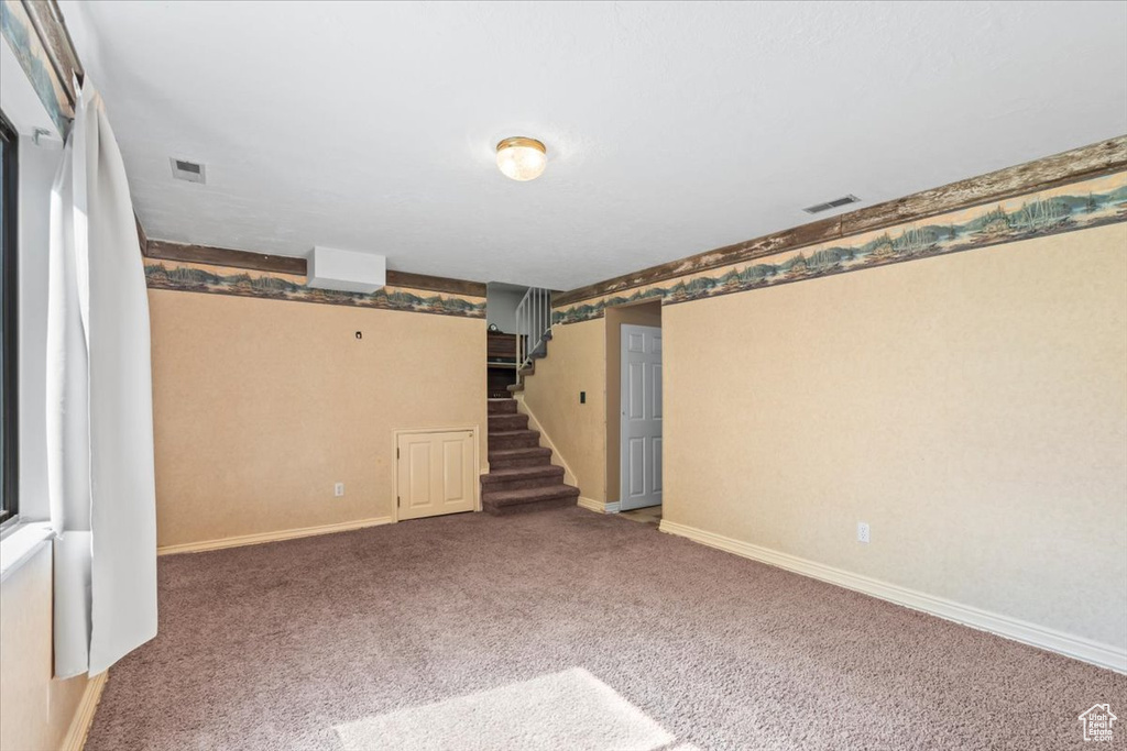 Basement with stairs, carpet floors, and wallpapered walls