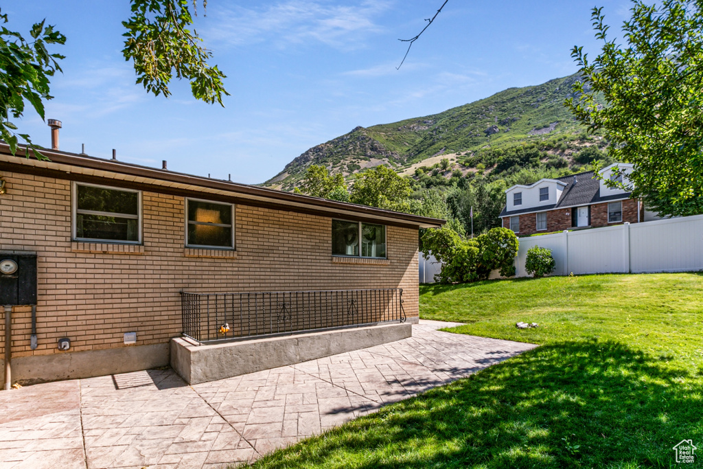 Rear view of property featuring a mountain view, a patio area, and brick siding