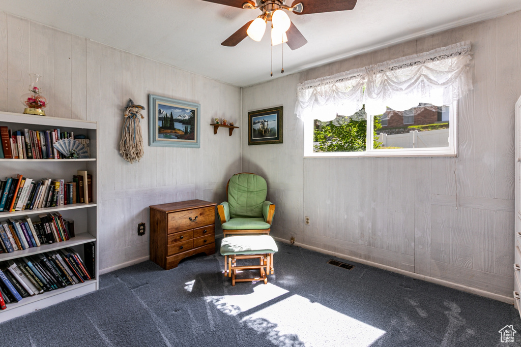 Living area featuring carpet and ceiling fan