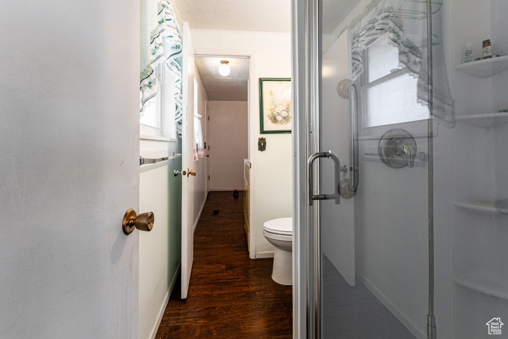 Full bath with wood finished floors and a shower stall