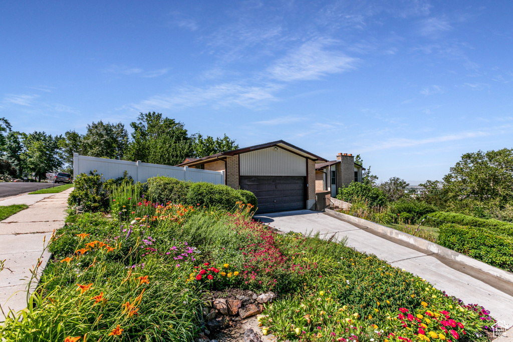 Mid-century home with driveway, brick siding, and an attached garage