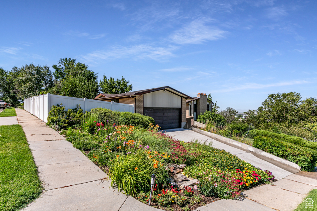 Mid-century modern home with driveway, brick siding, and a garage
