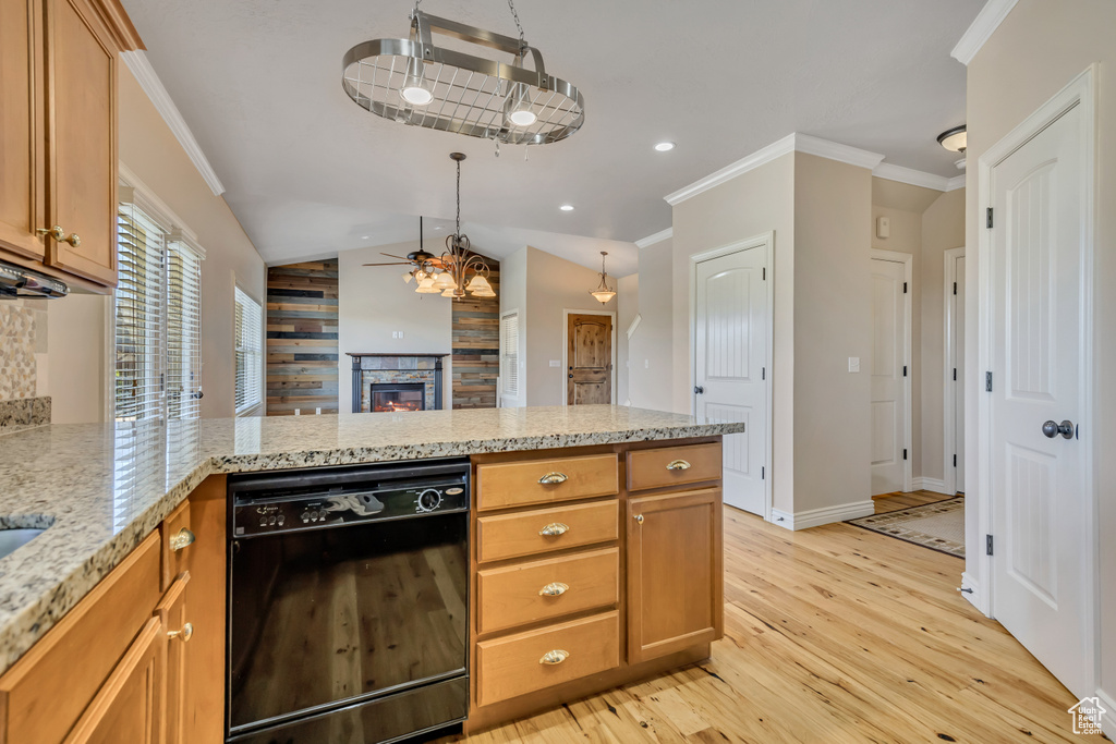 Kitchen featuring dishwasher, a peninsula, light wood-style floors, ornamental molding, and a stone fireplace
