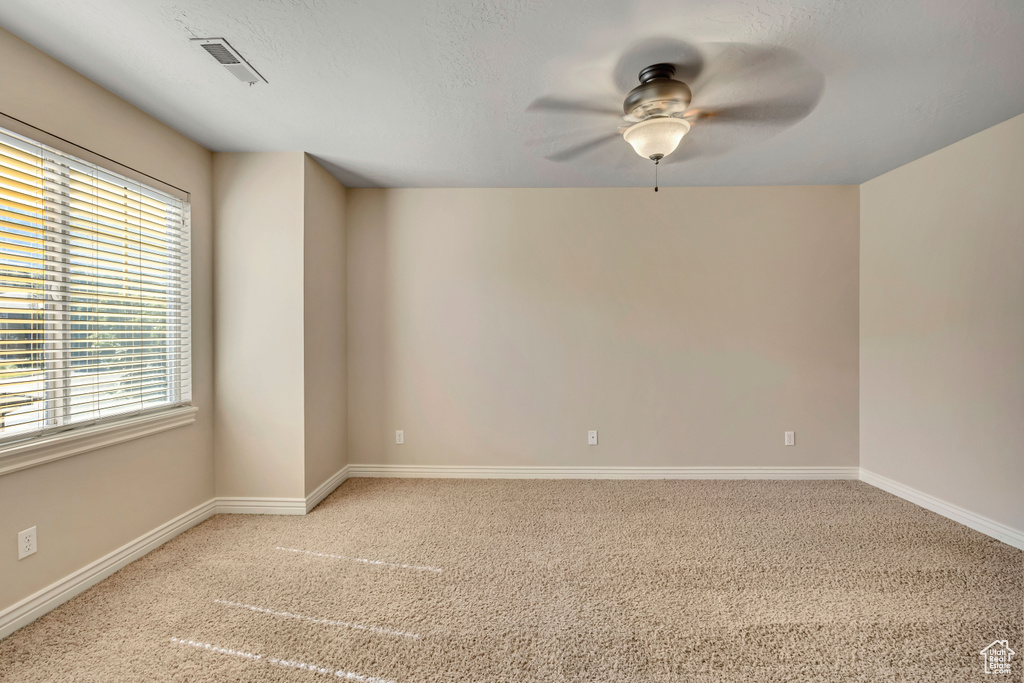 Unfurnished room featuring a ceiling fan and carpet flooring