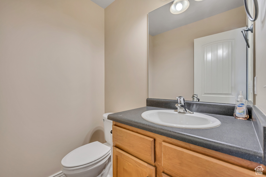 Half bathroom featuring vanity and toilet