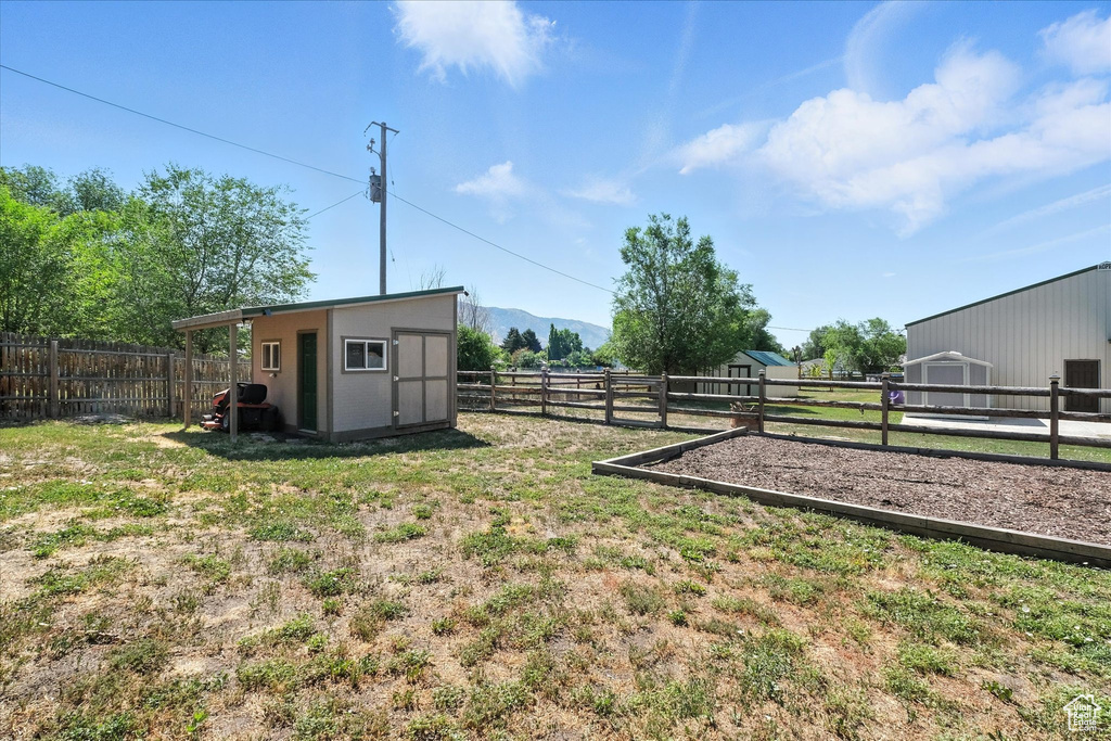 Fenced backyard with a storage unit and a mountain view