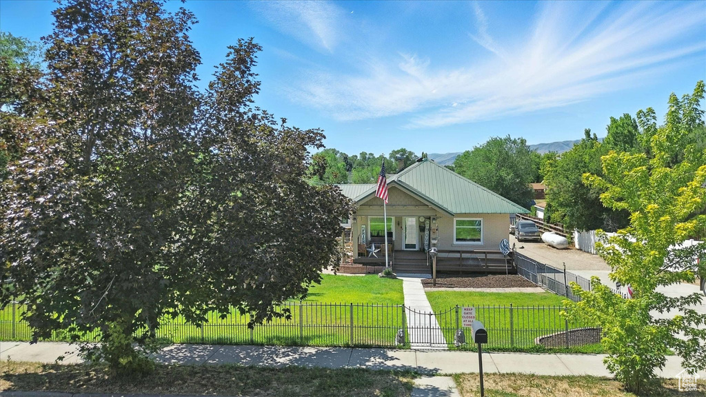 View of front facade featuring a porch, a fenced front yard, and a mountain view