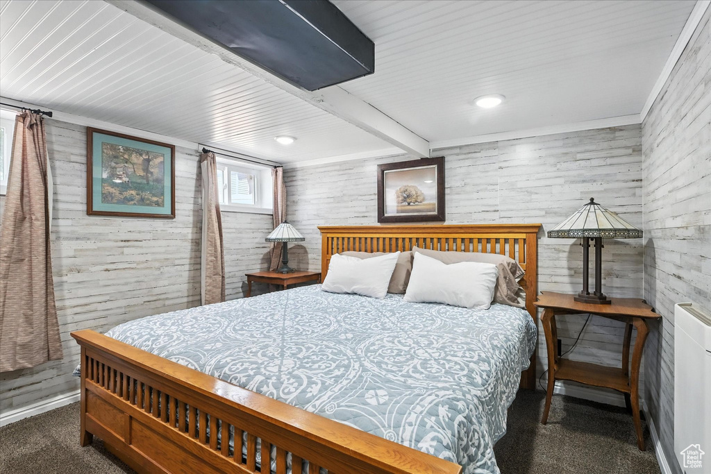 Bedroom featuring wooden walls, beam ceiling, and recessed lighting
