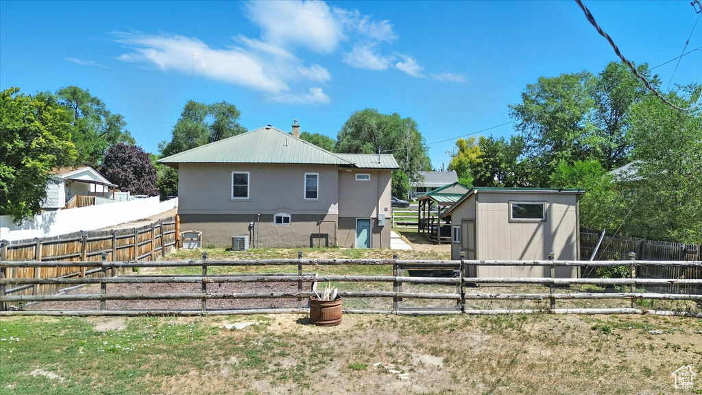 Back of property featuring a shed and a metal roof