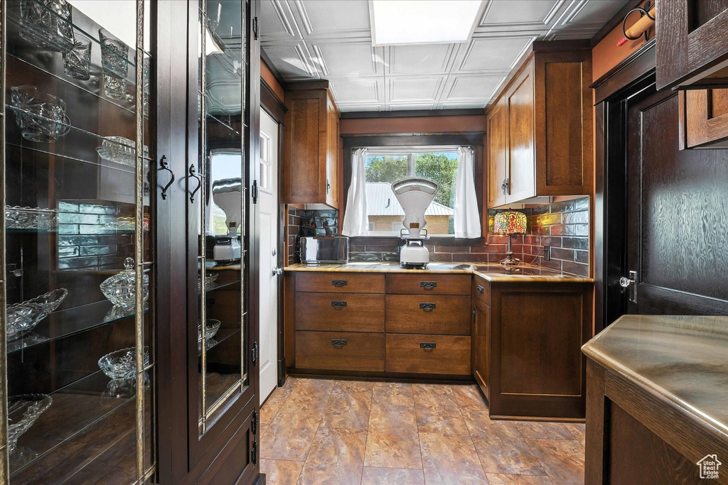 Kitchen with decorative backsplash, an ornate ceiling, and light countertops