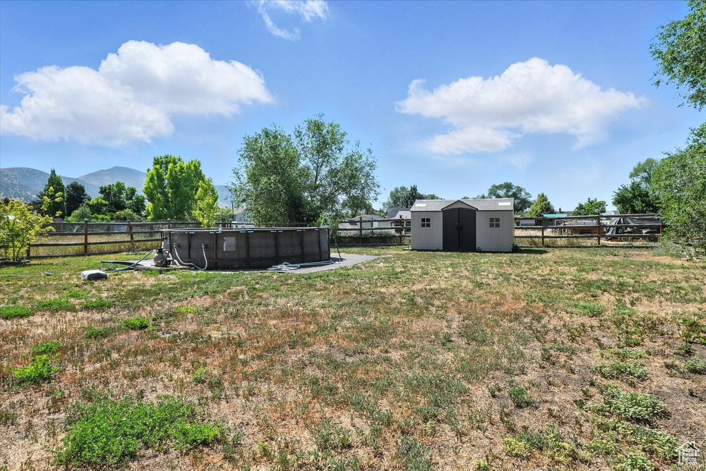 Fenced backyard with a shed and a mountain view