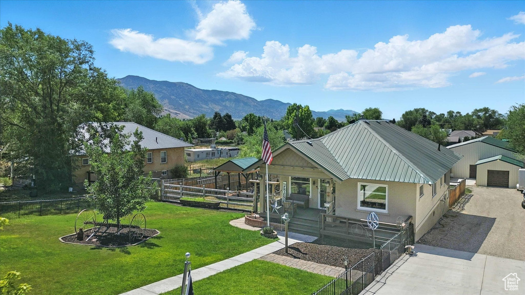 View of front of property with driveway, a porch, a metal roof, and a mountain view