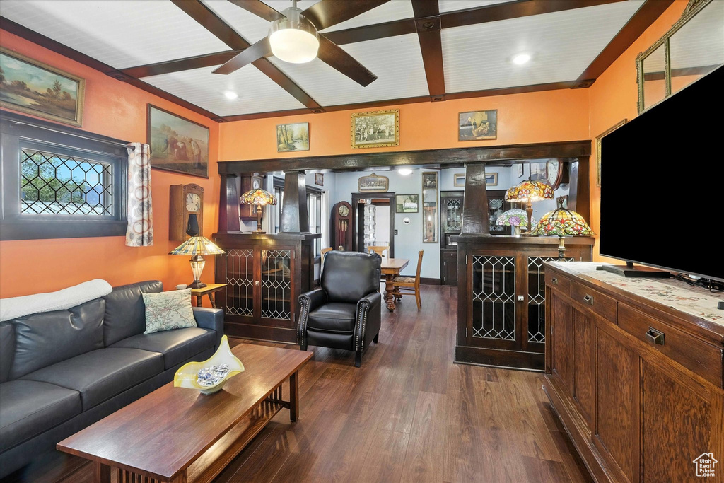 Living area with dark wood-type flooring, beamed ceiling, and ceiling fan