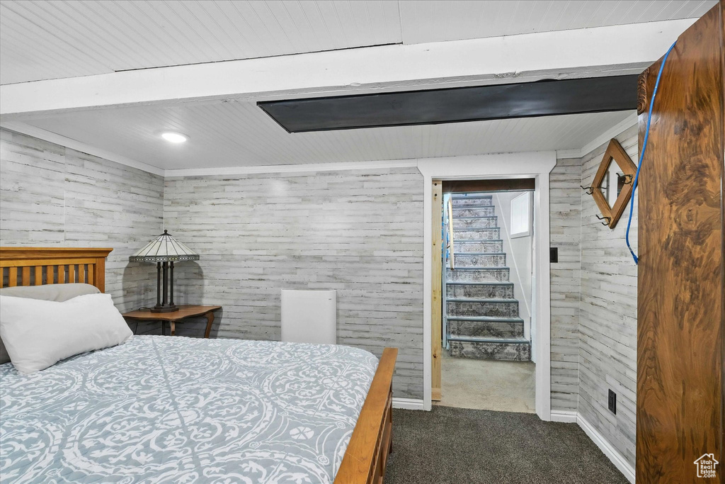 Bedroom with dark carpet and baseboards