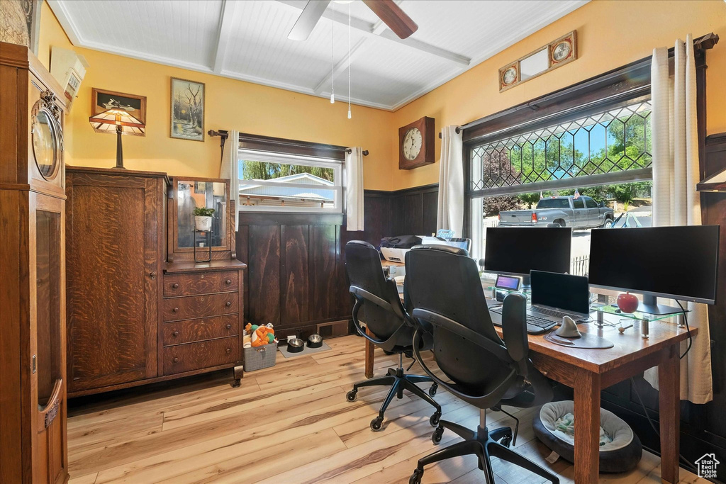 Home office with wainscoting, light wood-style floors, and a ceiling fan