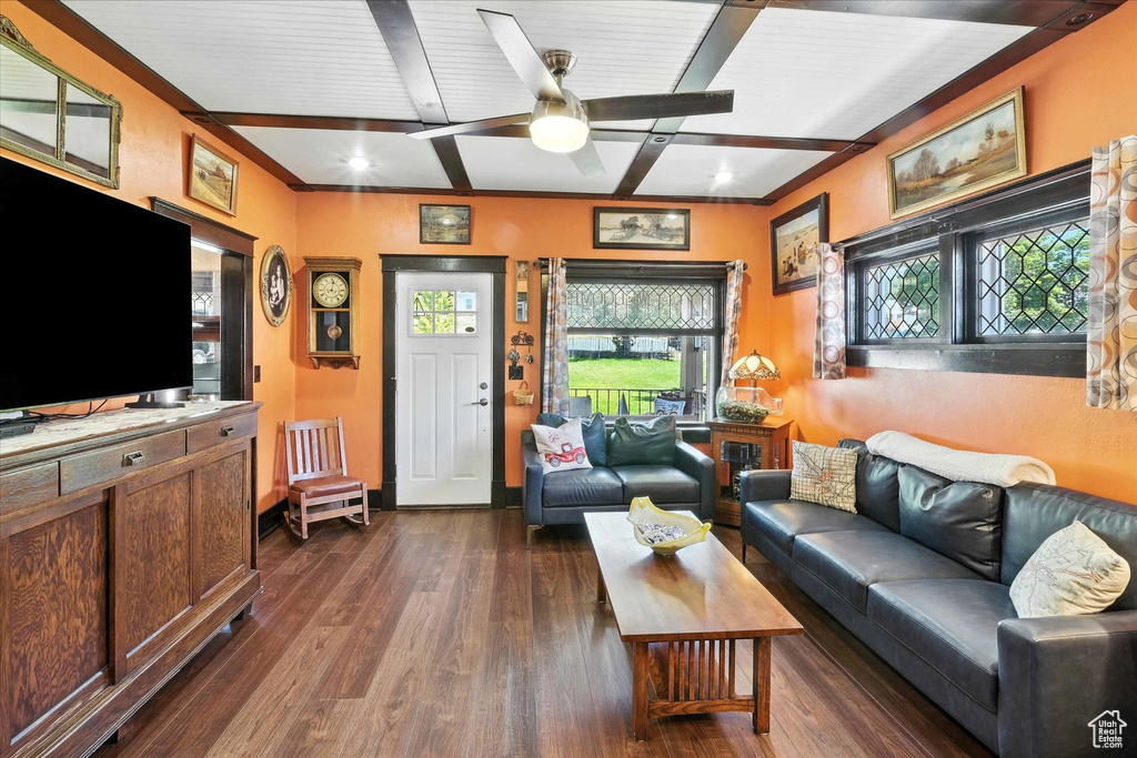 Living room with beam ceiling, ceiling fan, and dark wood finished floors