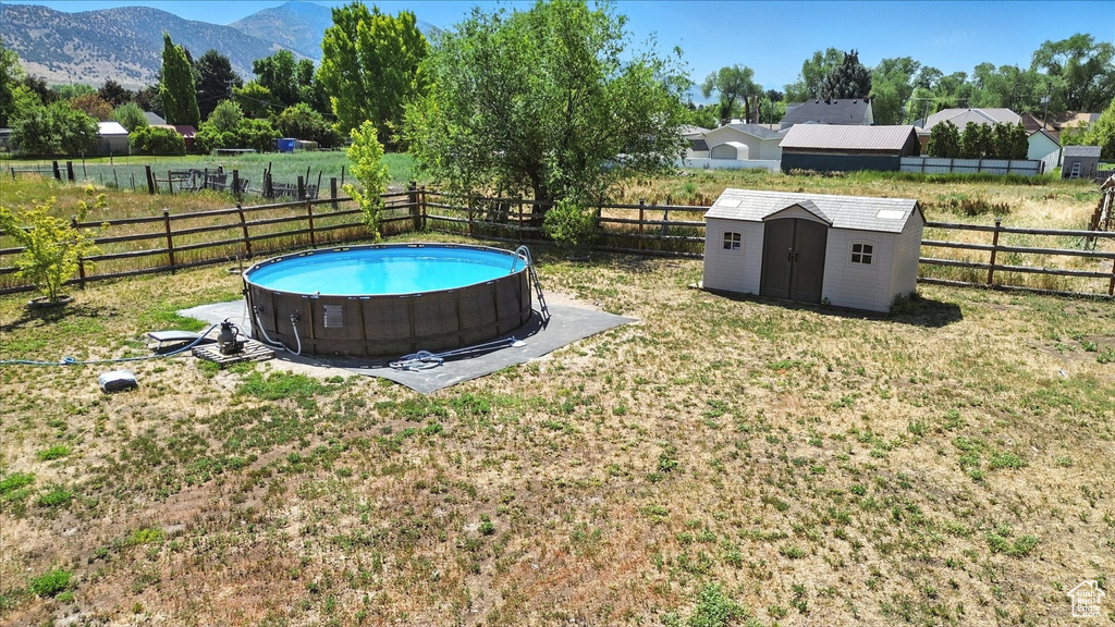 Fenced backyard with a storage shed and a mountain view