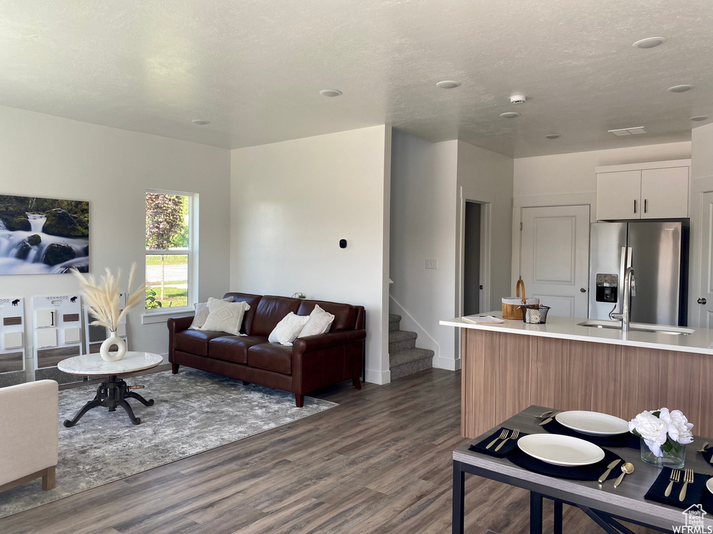 Living room featuring dark wood-type flooring and stairs