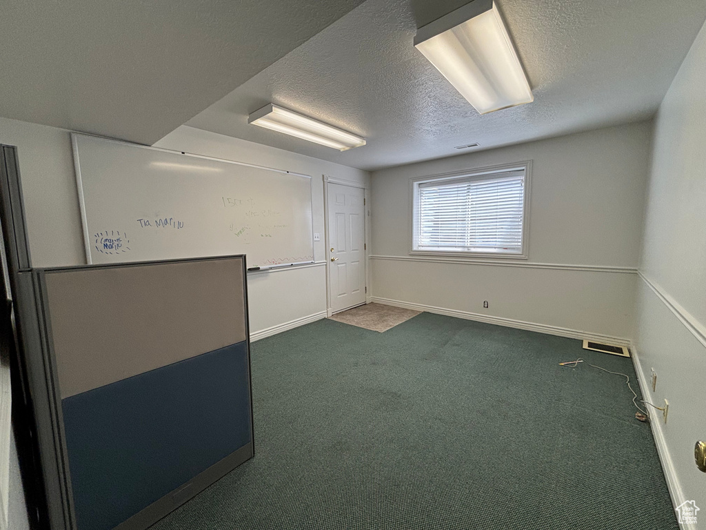 Carpeted spare room featuring a textured ceiling