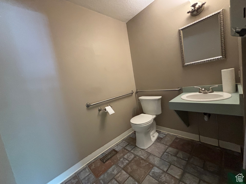 Bathroom featuring stone tile flooring and a textured ceiling