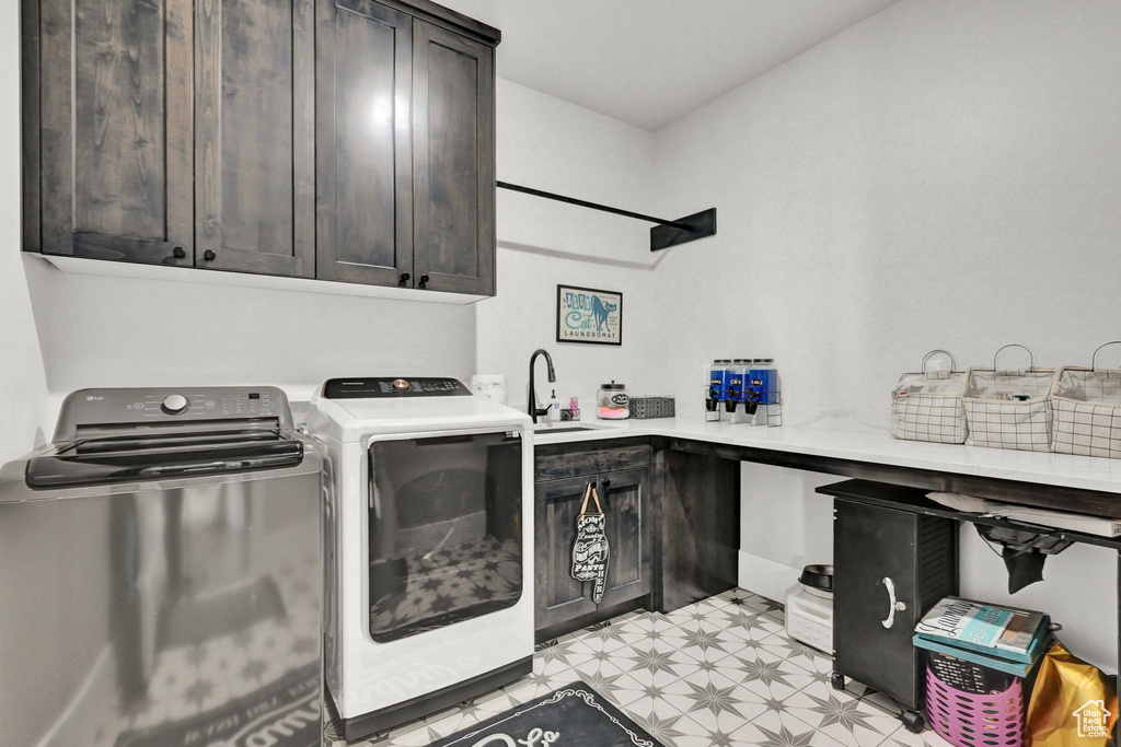 Laundry room with cabinet space, washing machine and clothes dryer, and light flooring