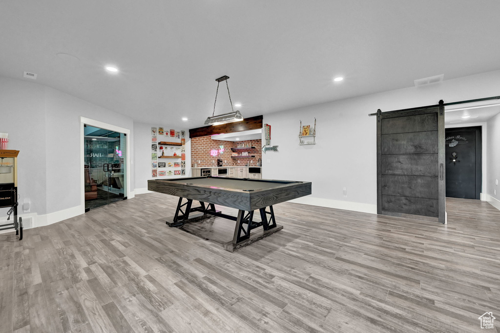 Recreation room featuring a bar, recessed lighting, wood finished floors, pool table, and a barn door