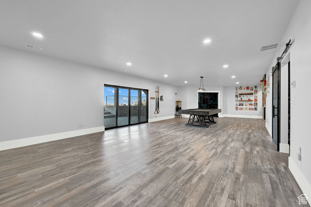 Living room featuring a barn door, wood finished floors, and recessed lighting