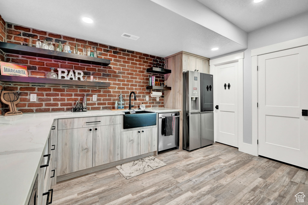 Kitchen featuring open shelves, appliances with stainless steel finishes, light wood finished floors, recessed lighting, and light stone counters