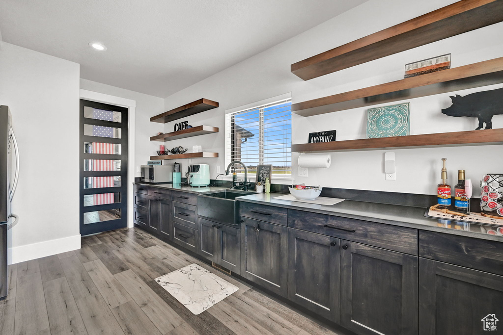 Kitchen featuring open shelves, light wood-type flooring, recessed lighting, and freestanding refrigerator