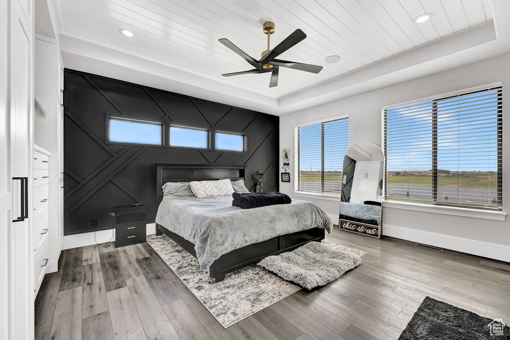 Bedroom featuring a tray ceiling, wood finished floors, recessed lighting, a ceiling fan, and wood ceiling