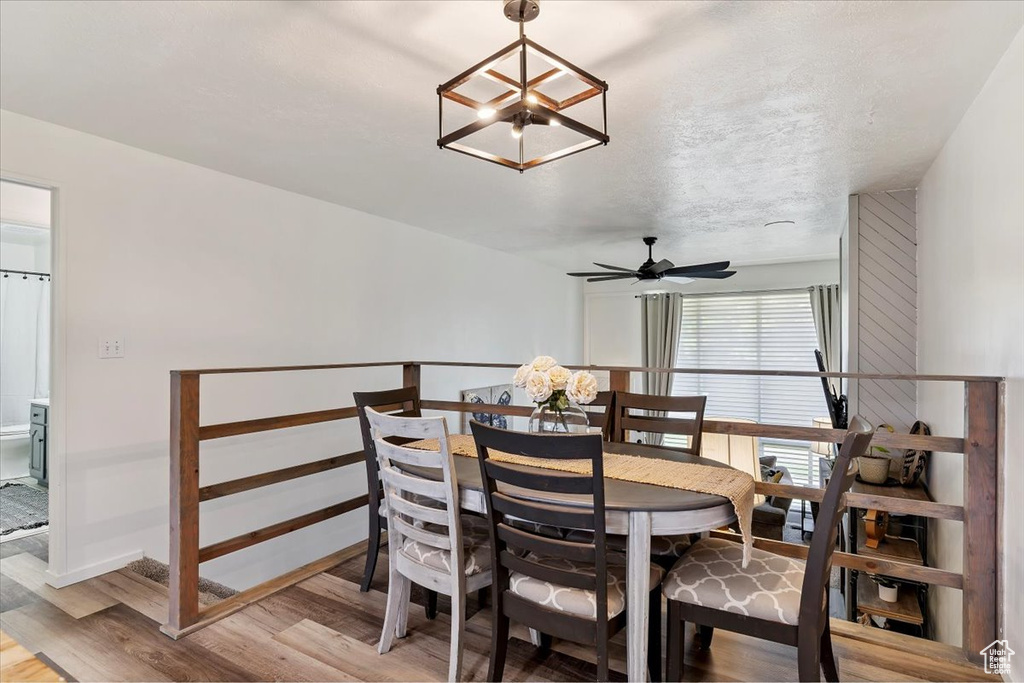 Dining space with light wood-type flooring, a chandelier, and ceiling fan