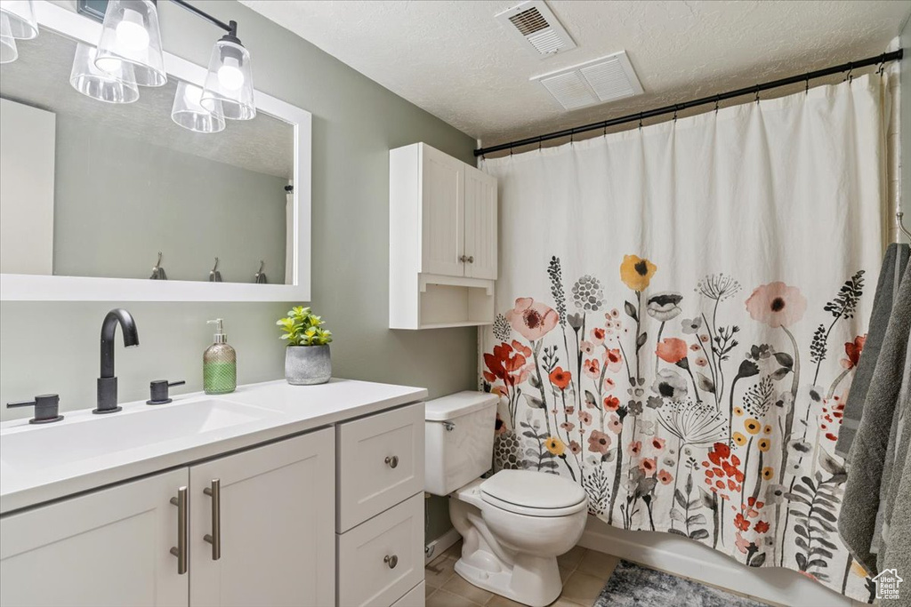 Bathroom with vanity, tile patterned floors, and a textured ceiling