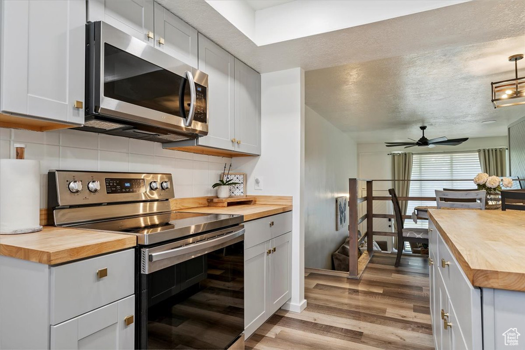 Kitchen featuring butcher block countertops, stainless steel appliances, and light wood-style floors