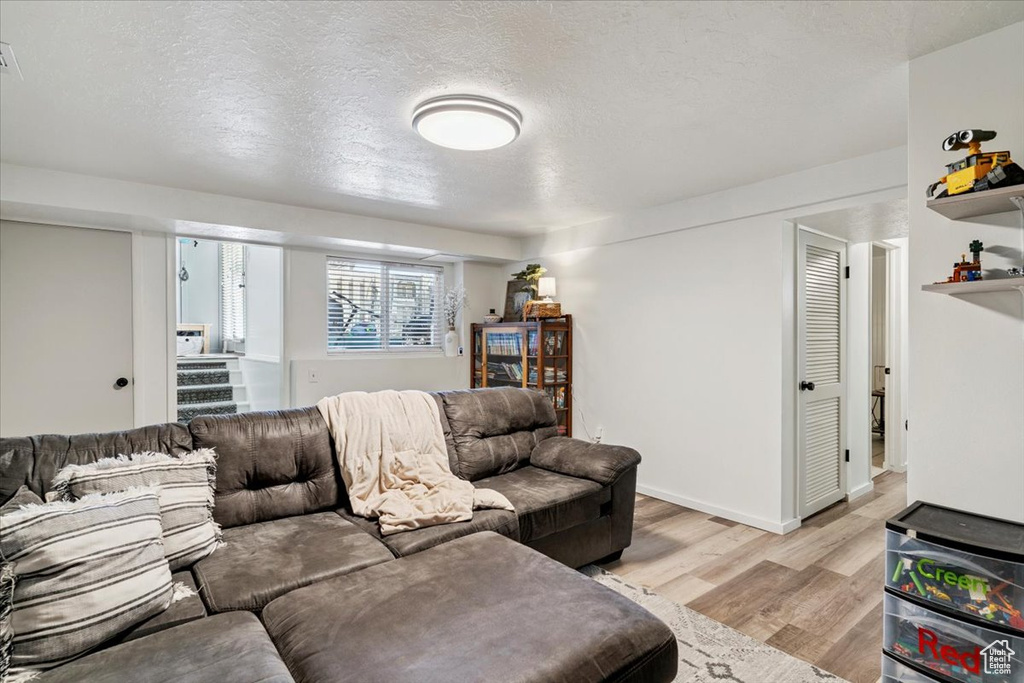 Living area featuring light wood finished floors and a textured ceiling