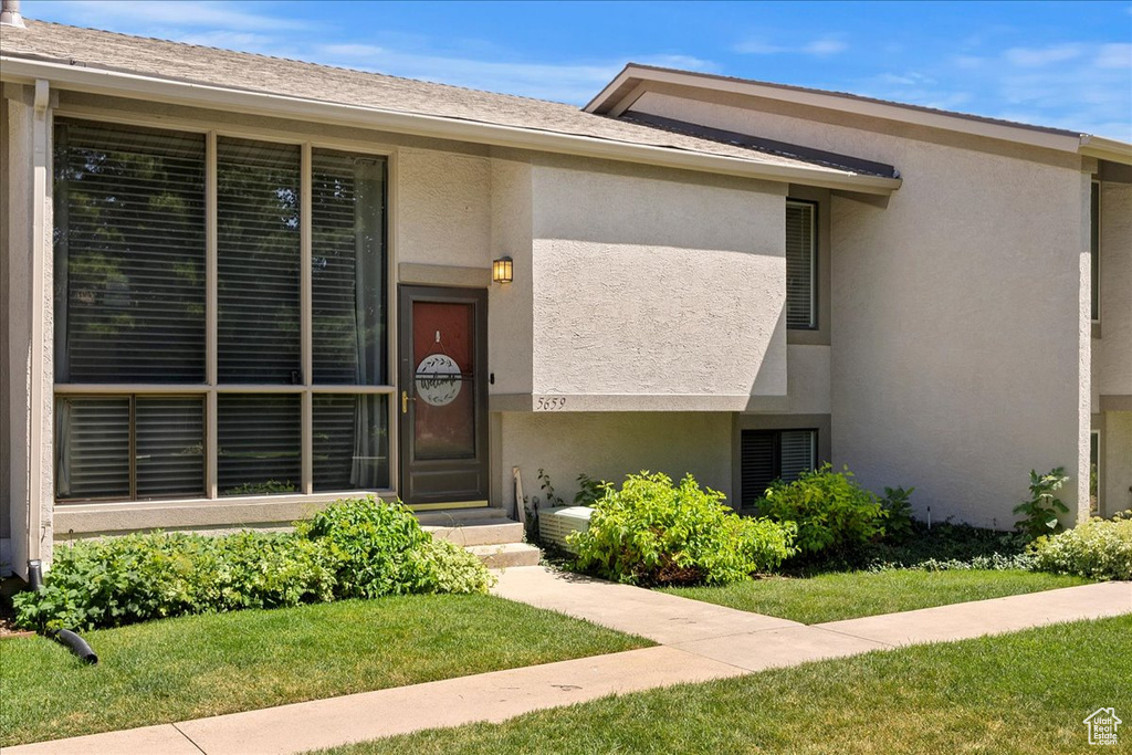 View of front facade featuring stucco siding and a front lawn