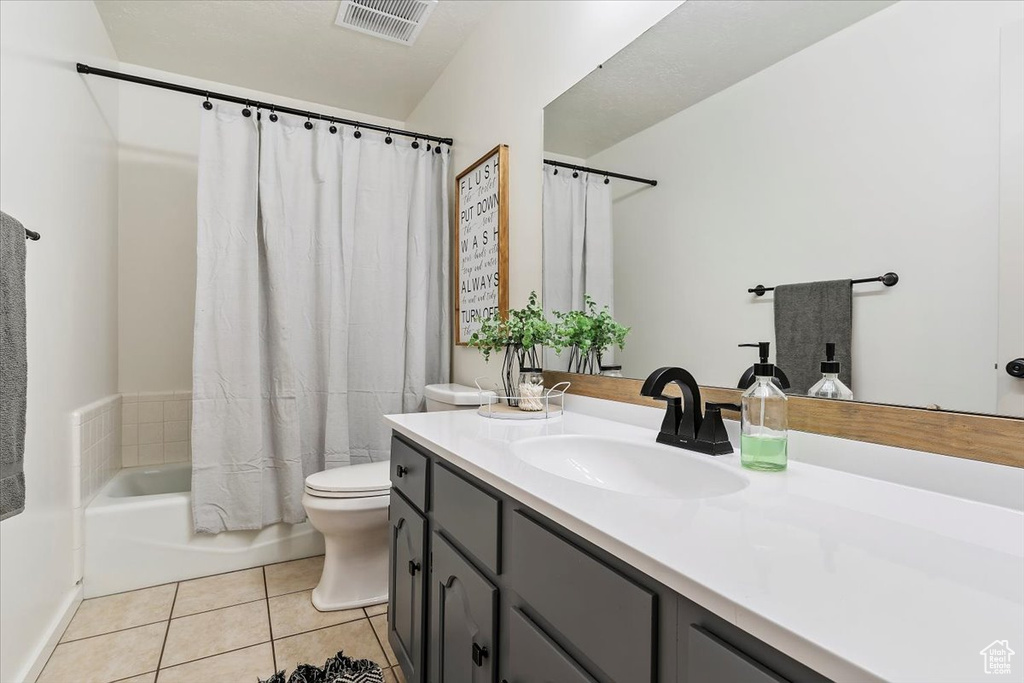 Bathroom featuring vanity, tile patterned floors, and shower / tub combo with curtain