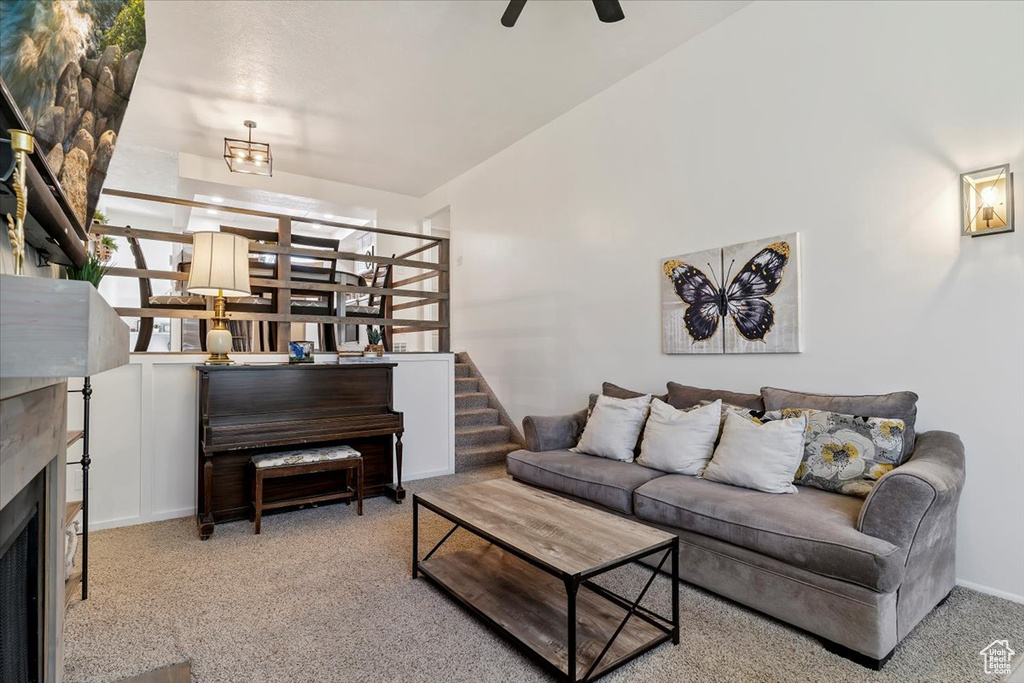 Carpeted living room with ceiling fan and a fireplace