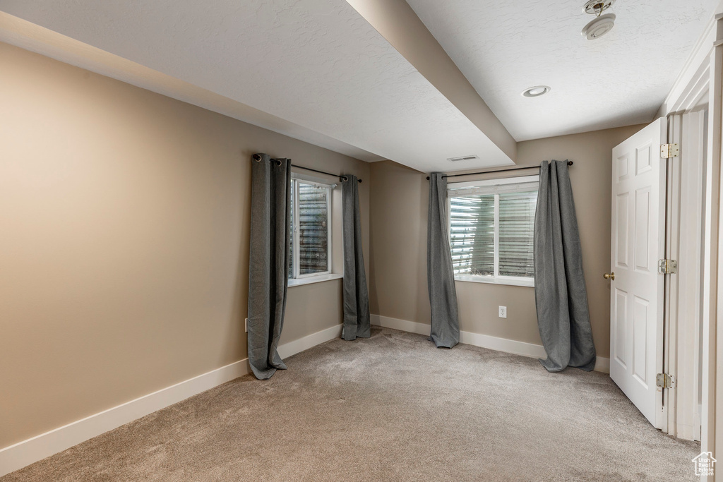 Unfurnished bedroom featuring light carpet and baseboards